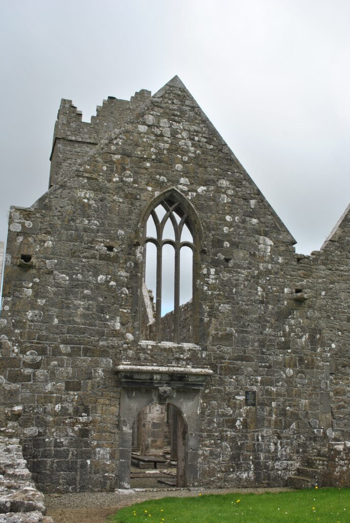 Moyne Abbey east gable, showing the switchline-tracery window above a later doorway