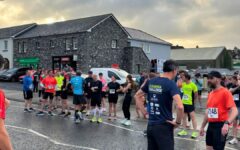 Runners gathered at the start line of the Ó Dubhda Challenge in Enniscrone, with the Old Church visible in the background and West Sligo AC branding on the photo